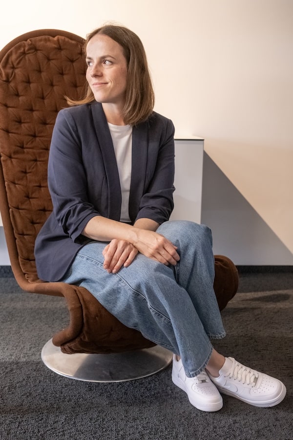 Ingrid Clivia Königshofer sitzt in einem modernen Stuhl